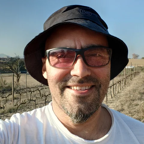 Xavi, responsable de màrqueting de XBVins, somrient a la vinya un dia d'estiu